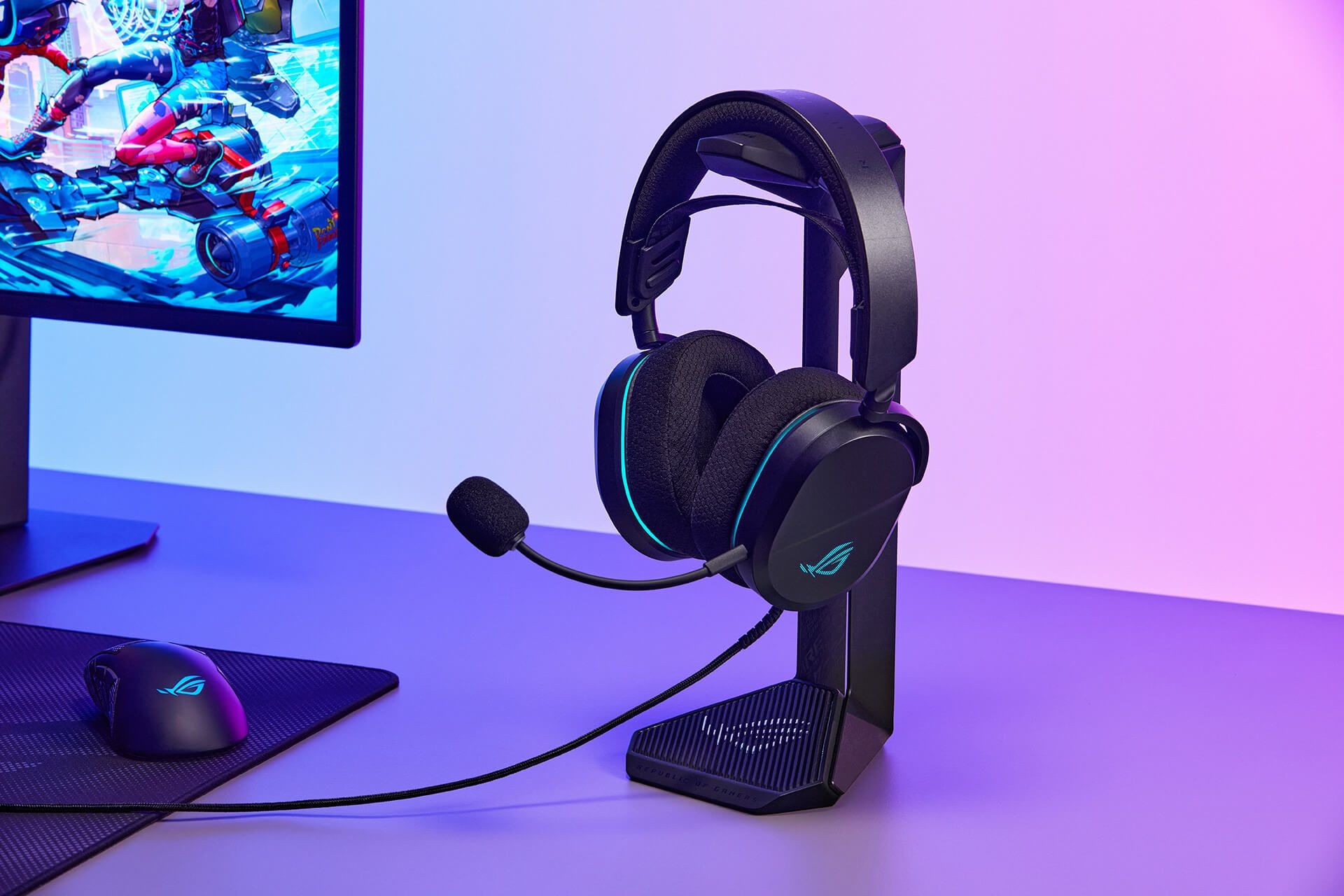 Чорна гарнітура ASUS ROG Pelta Core стоїть на підставці поруч із монітором.